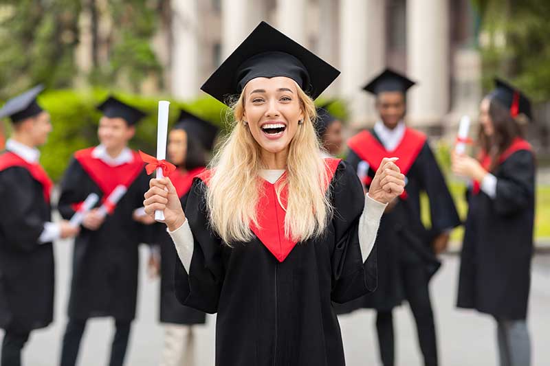 a graduation party venue in quincy ma - photo of young woman in graduation gown and cap, excited immediately after her graduation