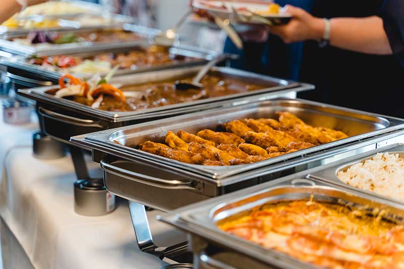 food catering services south shore ma - photo of Buffet food service at event banquet, stainless steel catering trays with assorted hot dishes, people serving themselves