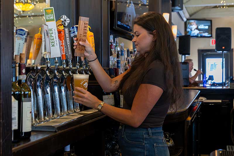at the fox & hound restaurant & bar, a bartender pours a beer from the tap