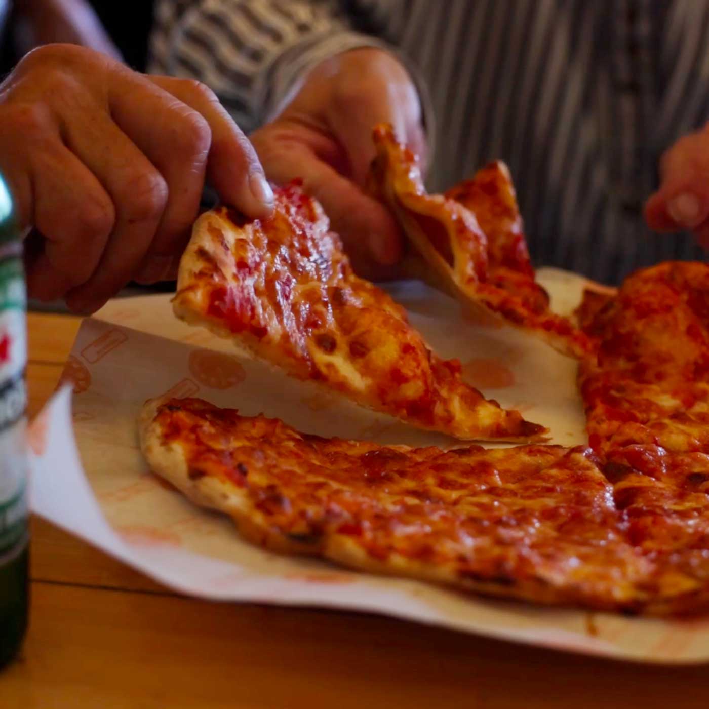 people sharing a pizza